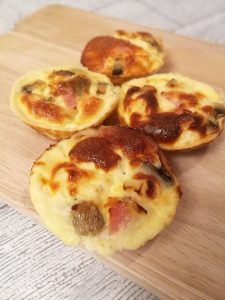 Mini crustless Quiches - 4 small muffin-like quiches on a wooden board.