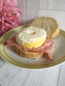 McDonald's Style Egg on top of some bacon in a brown roll.