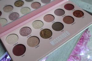 January Makeup Favourites - A pale pink case with MISSGUIDED written along the bottom, 12 different coloured, round eyeshadow pans and a mirror on the lid which is reflecting the pans.