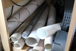 Living With A Blogger - sample rolls of wallpaper on top of each other under a small desk.