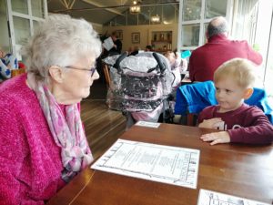 Loneliness in the elderly - An elderly lady and toddler boy sat at a table 