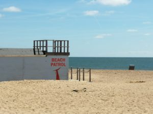 Getting the perfect beach body - A blue hut on the sand with "Beach Patrol" written on the side overlooking the sea