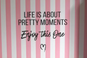 A pink and white striped background with the words "Life is about pretty moments. Enjoy this one"