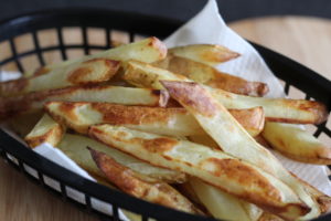 Rosemary and garlic baked fries - a black basket filled with chips.