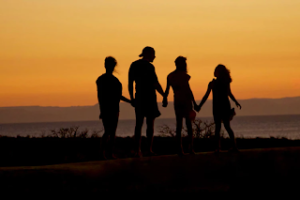 Tough times as a parent - silhouette of a family against a sunset 