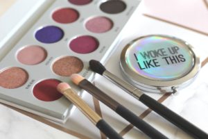 5 beauty tips I would give to my daughter - an eyeshadow palette open with 3 brushes perched on the edge and a compact with "I woke up like this" written on the top.