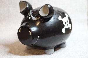 No Spend January - A black piggy bank with a pirate eye patch and a skull and crossbones on its side