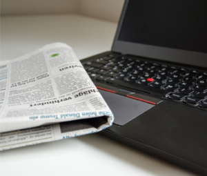 Remove negativity from your life - a newspaper folded and resting on top of an open laptop