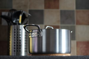 Minced Beef Hotpot - Silver Casserole PAn sat on a cork mat and shot from a below angle