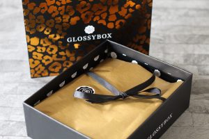 My last ever Glossybox - The open black box with the leopard print lid stood behind it, revealing the gold paper and black bow inside.