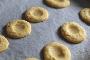 plain biscuits with little dents in the top ready for the lemon curd