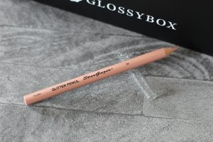 A peach coloured eyeliner pencil with my last ever Glossybox in the background