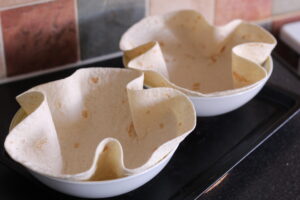 Two bowls containing wraps ready to make Taco Salad Bowls